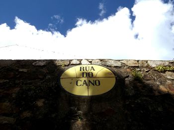 Road sign against cloudy sky