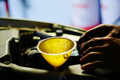 Close-up of hand holding engine oil 