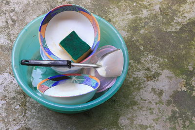 High angle view of paintbrushes in bowl on table