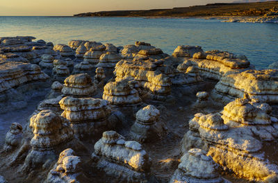 Rocks on sea shore against sky