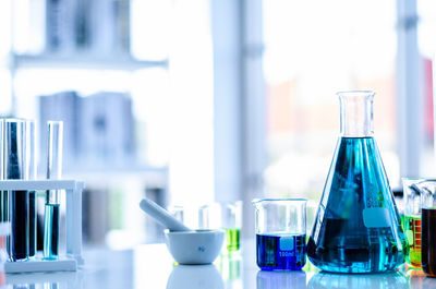 Close-up of liquids in beakers and test tubes on table at laboratory