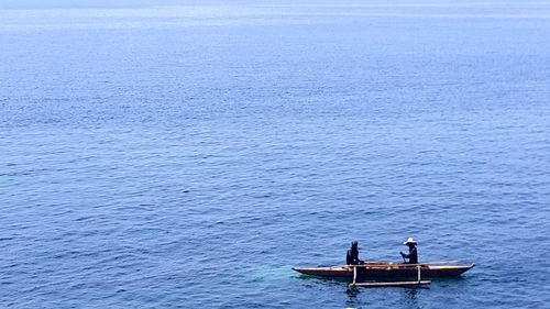 People rowing boat in sea