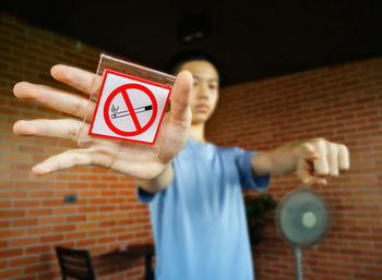 Midsection of man holding text against wall