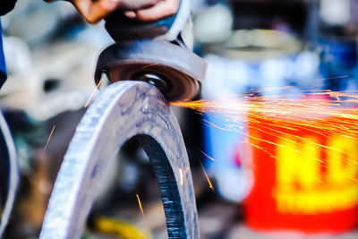 Close-up of person working on metal