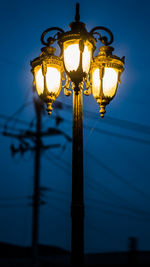 Low angle view of illuminated street light against sky during dusk