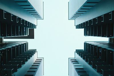 Directly below shot modern buildings against clear sky