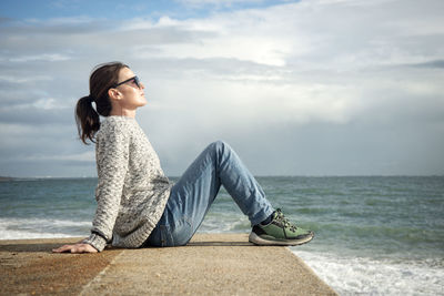 Portrait of young woman sitting at beach