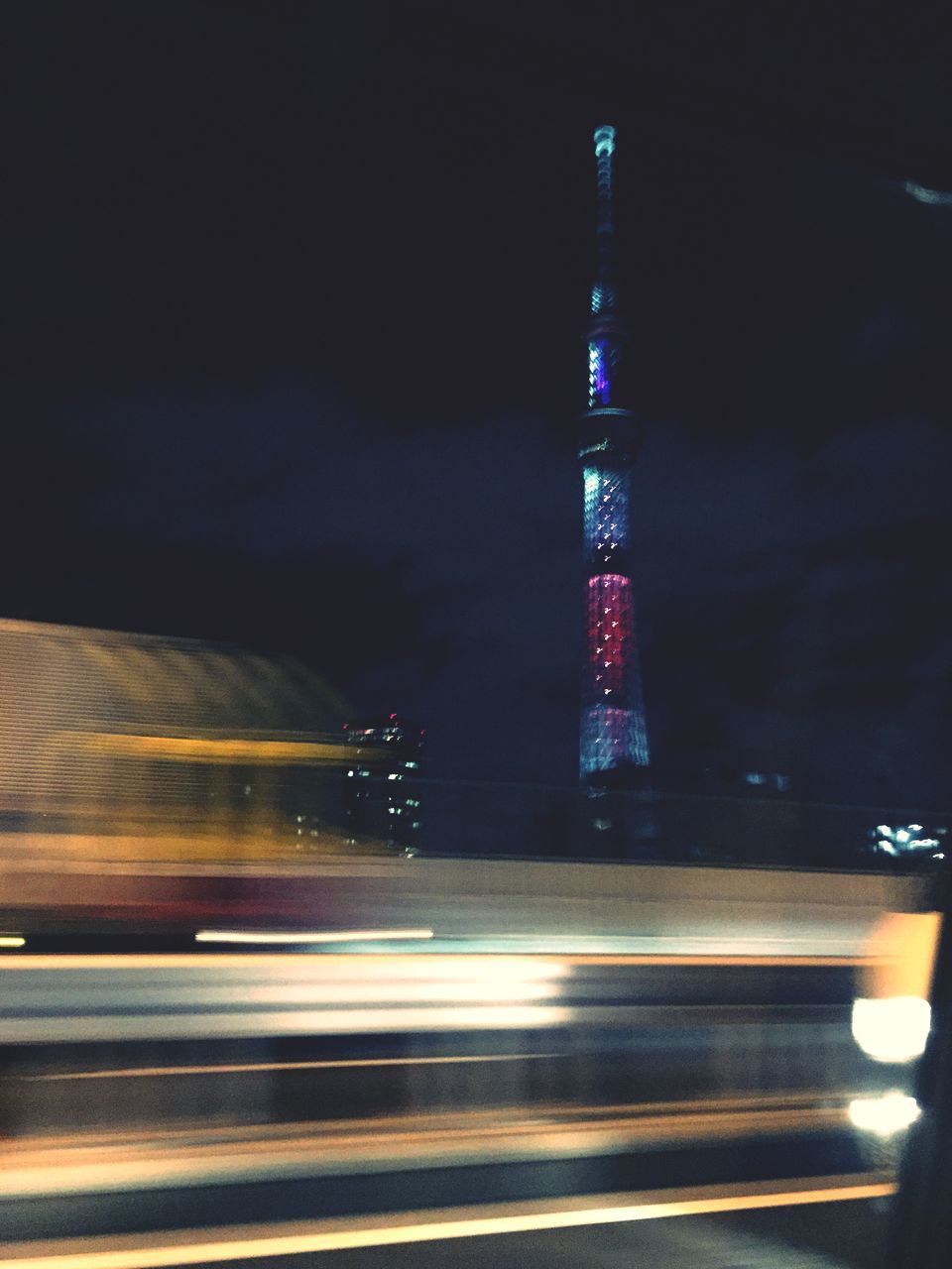 illuminated, night, long exposure, motion, city, light trail, architecture, speed, blurred motion, transportation, built structure, building exterior, road, tall - high, street, tower, skyscraper, on the move, travel, modern