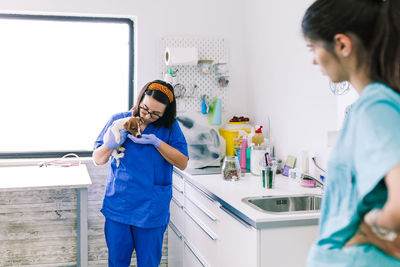 Female veterinarian cutting nails of puppy at clinic