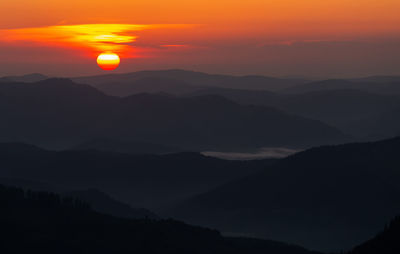 Scenic view of silhouette mountains against sky during sunset