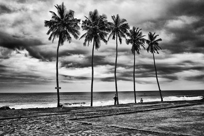 Scenic view of beach against cloudy sky