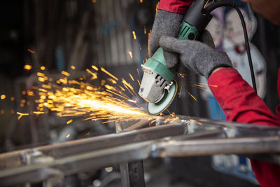 Welder used grinding stone on steel in factory with sparks, welding process at the industrial work