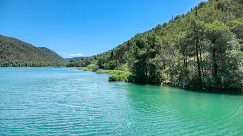 Scenic view of river at skradinski buk against clear blue sky