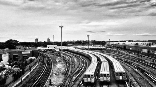 High angle view of railroad tracks by street against sky