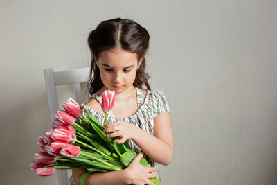 Girl with flowers sitting on chair