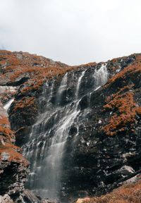 Scenic view of waterfall against sky