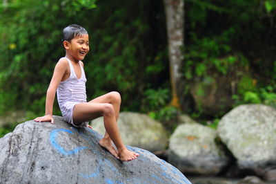 Boy sitting on rock