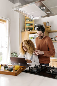 People holding food in kitchen