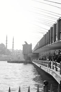 View of buildings by river against clear sky