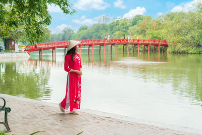 Rear view of woman standing by lake