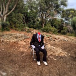 Full length of man sitting on dirt road