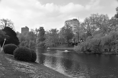 Scenic view of park by lake against sky