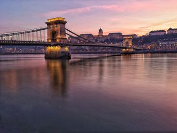 View of bridge over river at sunset