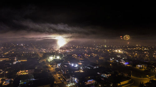 Aerial view of illuminated cityscape against sky at night