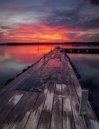 Pier over sea against sky during sunset