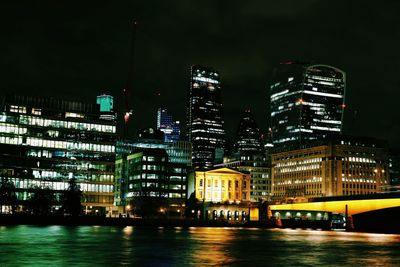 Illuminated 30 st mary axe and thames river in city at night