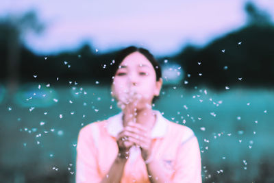 Close-up of young woman against sky