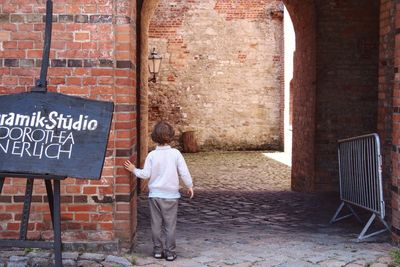 Man standing on brick wall