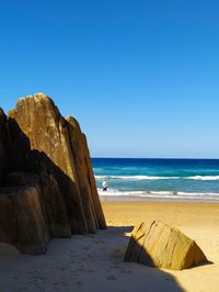 Scenic view of beach against clear blue sky