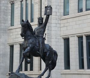 Low angle view of statue against building in city