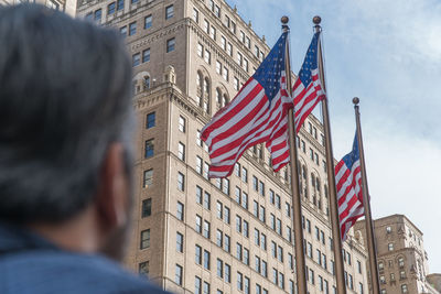 Low angle view of flags against buildings in city