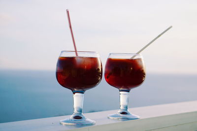 Close-up of wineglasses against sea