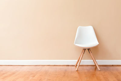 Empty chair on floor against wall at home