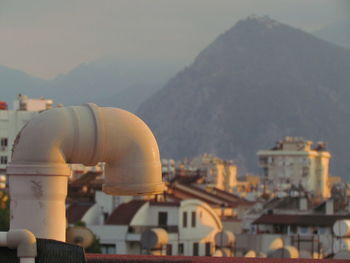 Aerial view of townscape and mountains against sky