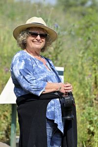 Young woman wearing hat while standing against trees