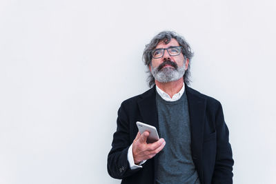 Portrait of young man standing against white background