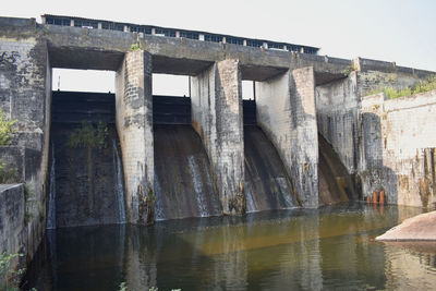 Low angle view of dam on river against sky