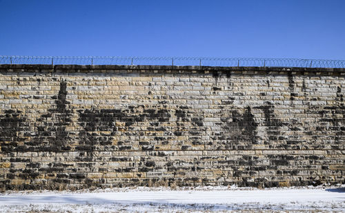 Abandoned prison wall brick and blue sky