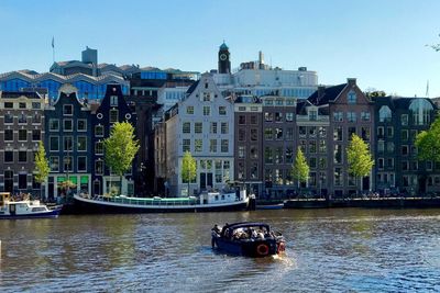 Boat in river with buildings in background