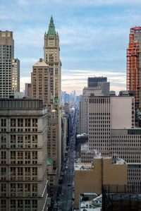 Buildings in city against cloudy sky