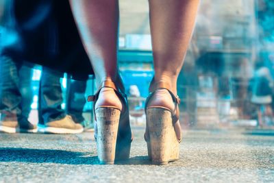Low section of woman standing on street