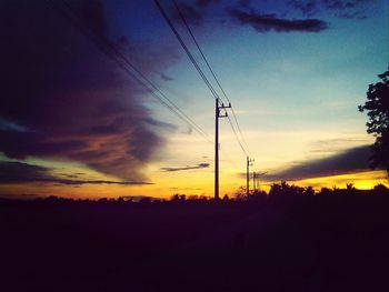 Silhouette of electricity pylon at sunset