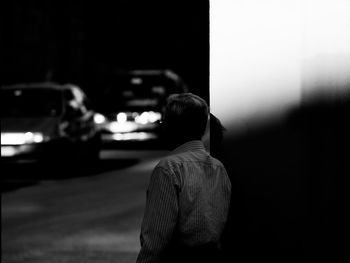 Rear view of man photographing at night