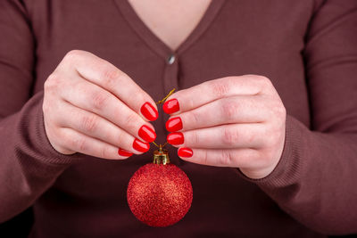 Midsection of woman holding christmas light bulb