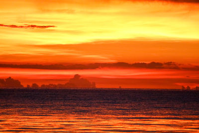 Scenic view of sea against dramatic sky during sunset