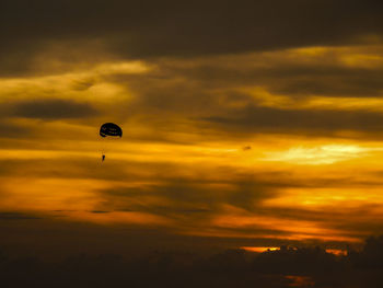 Low angle view of kite in sky at sunset